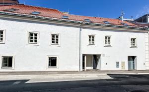 a white building with a red roof at Zentrales, klimatisiertes Apartment Nähe Spital & FH in Wiener Neustadt