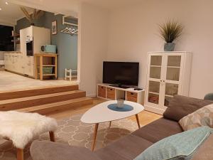 a living room with a couch and a tv at Ferienwohnung am Schöhsee in Plön