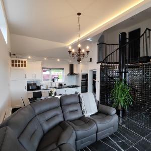 a living room with a couch and a kitchen at An Camus Ballyliffin in Ballyliffin