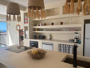 a kitchen with a counter with a bowl of fruit on it at Villa exceptionnelle en bord de mer - SUNSET VILLA in Pointe-Noire +22 photos