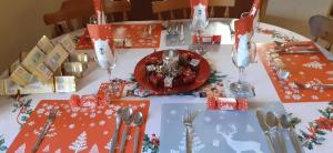 a table with a christmas table cloth with a plate on it at Henblas Holiday Cottages in Abergele +19 photos