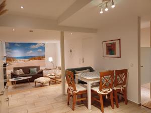 a living room with a table and chairs and a couch at Ferienwohnung am Schöhsee in Plön