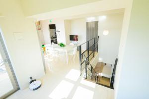 a room with a staircase and a table with chairs at Trh Sophia in Miyazaki