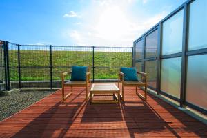 two chairs and a table on the balcony of a building at Trh Sophia in Miyazaki