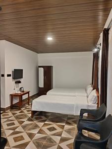 a bedroom with a bed and a chair and a television at Coralberry Inn in Jāmb