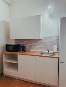 a kitchen with a microwave and a sink at Foresteria Tosi in San Colombano al Lambro