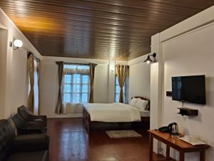 a hotel room with a bed and a tv at Coralberry Inn in Jāmb