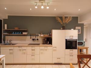 a kitchen with white cabinets and a refrigerator at Ferienwohnung am Schöhsee in Plön