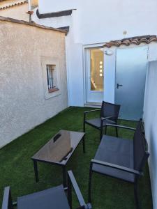 a patio with chairs and a table and a window at Maison mitoyenne in Gignac-la-Nerthe