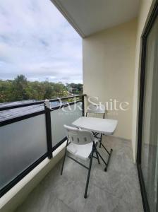 a balcony with a white chair and a window at Oak Suite in Baguio