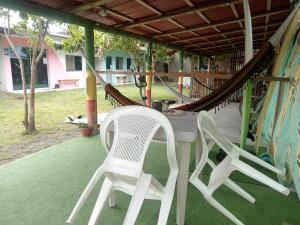 two chairs and a table and a hammock on a porch at La tribu in Simiátug