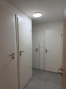 an empty room with two doors and a tile floor at Zentrale Gästezimmer am Marienplatz - London in Stuttgart
