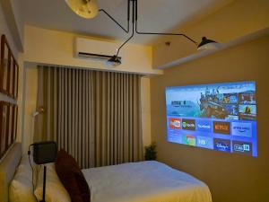 a bedroom with a bed and a tv on the wall at The Florentine Suite in Manila