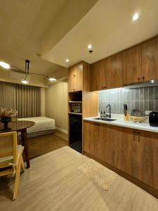 a kitchen with a sink and a table and a bed at The Florentine Suite in Manila