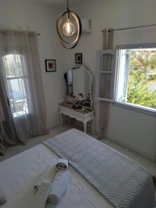 a bedroom with a large bed and a mirror at Κυκλαδίτικο σπίτι με θέα Villa Mimika in Perissa