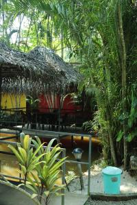 a restaurant with a straw hut with chairs and trees at Greenbay Beach Resort in Varkala +23 photos