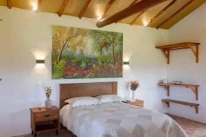a bedroom with a large painting above a bed at Trinitarios in Barichara