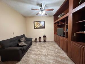 a living room with a couch and a ceiling fan at Colimota in Colima