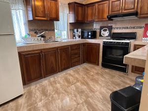 a kitchen with wooden cabinets and black appliances at Colimota in Colima
