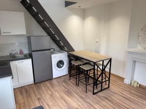 a kitchen with a table and a washer and dryer at Jolie duplex face à la Seine in Villeneuve-le-Roi