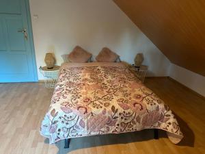 a bedroom with a bed with a colorful comforter at Agroturystyka OLD ROAD 11 in Niedźwiedź