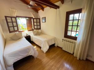 a bedroom with two beds and two windows at Hotel L' Hirondelle in La Falda +48 photos