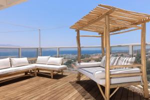 a balcony with two white chairs and a pergola at Kedem Eilat קדם אילת in Eilat
