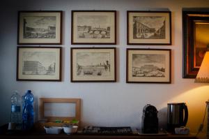 a wall with framed pictures on a wall at Soggiorno Michelangelo in Florence