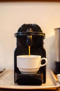 a coffee maker is pouring coffee into a cup at Soggiorno Michelangelo in Florence +36 photos