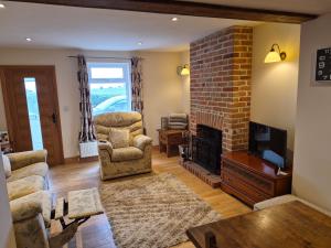 a living room with a couch and a fireplace at Coastline cottage Pakefield, 2 minutes walk to the beach in Pakefield