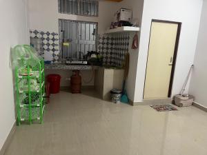 a living room with a kitchen with a green cage at Jinkos Homestay with self cooking facility in Itānagar
