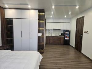 a bedroom with a white bed and a kitchen at Sora Hotel in Thường Son