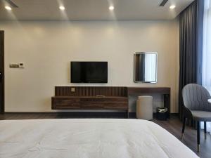 a bedroom with a flat screen tv on a wall at Sora Hotel in Thường Son