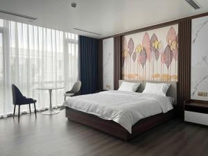 a bedroom with a large bed and a table at Sora Hotel in Thường Son