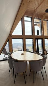 a wooden table and chairs in a room with windows at La Salcami in Burzuc