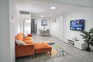 a living room with a couch and a tv at Chill Haven in Kingston