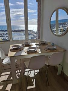 a dining room with a table with chairs and a mirror at Candela's Beach Port in El Masnou