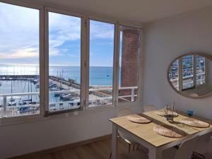 a dining room with a table and a view of the ocean at Candela's Beach Port in El Masnou