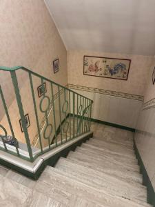 a staircase with a green railing in a room at Appartement 3 pièces in Mareil-Marly