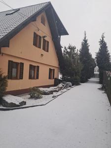 a snow covered driveway next to a house at Stara Kuźnia in Sosnówka
