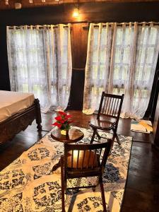 a room with two chairs and a table and a bed at Greenbay Beach Resort in Varkala
