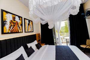 a bedroom with a white bed and a window at One Click Cozy Suites in Kigali