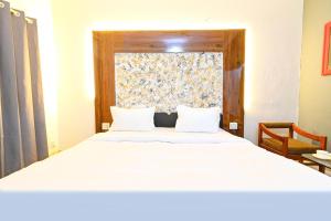 a bedroom with a large white bed with a window at FabHotel Classic Holidays in Jaipur