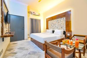 a bedroom with a bed and a table and a television at FabHotel Classic Holidays in Jaipur