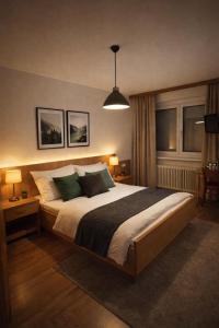 a bedroom with a large bed with two tables and a lamp at Motel Haid in Linz