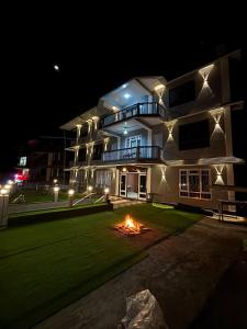 a building with a fire in front of it at night at Hotel Sunrise in Sāmthar