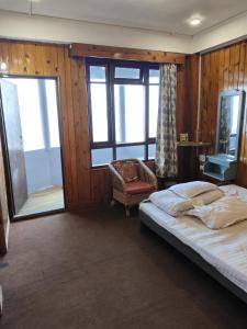 a bedroom with a bed in a room with windows at Hotel Sunrise in Sāmthar