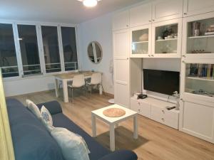 a living room with a blue couch and a table at Candela's Beach Port in El Masnou