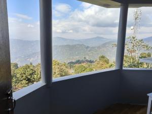 a room with a large window with a view of mountains at Hotel Sunrise in Sāmthar