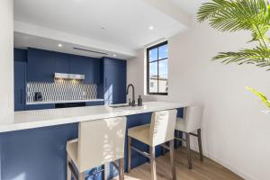 a kitchen with blue cabinets and white countertops at The Avenue Coral Gables in Miami